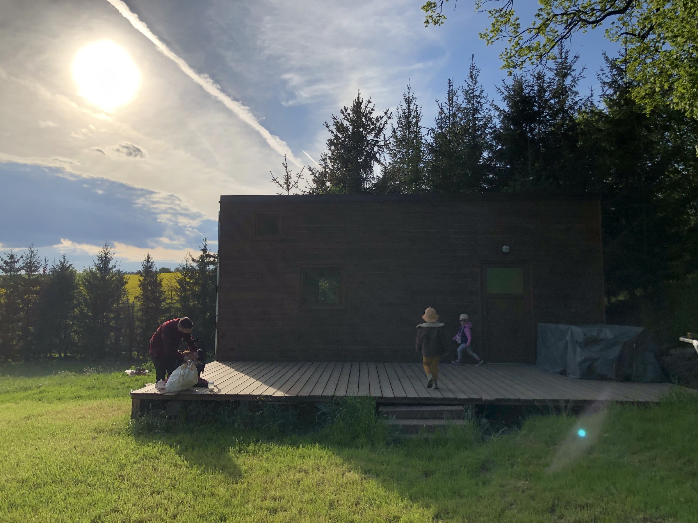 Tiny house s terasou v přírodě — západ slunce